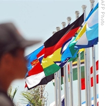 A man stands next to flags in front of East Timor's president office as part of preparation for the 10th anniversary of independence in Dili, 26 Aug 2009