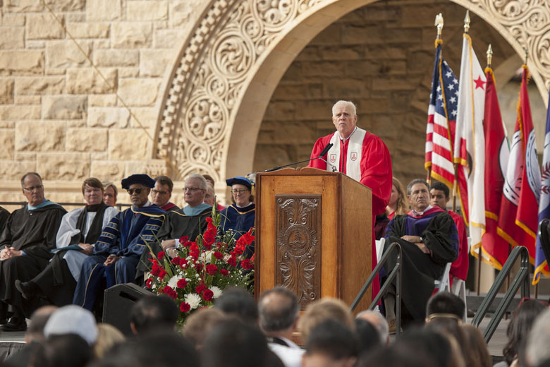 University President John Hennessy at lectern, with faculty on stage, at Stanford's 125th Opening Convocation / L.A. Cicero