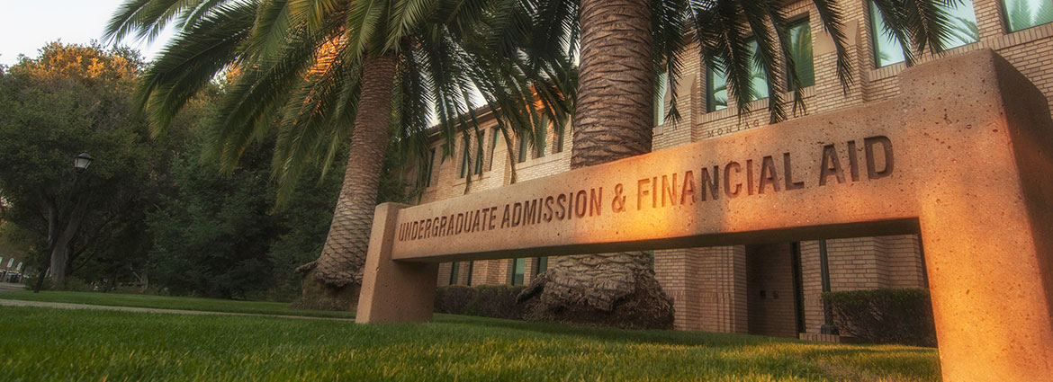 Montag Hall building with Financial Aid sign in front with palm trees in background