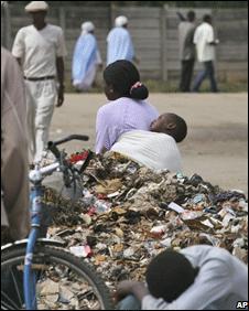 A woman and child rest by a rubbish tip in Harare, 7 December