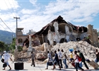 People walk by the collapsed Sacre Coeur Church in Port-au-Prince, on January 14, following the devastating earthquake that rocked Haiti on January 12. Desperate Haitians awaited a global effort to find and treat survivors from the quake that left streets strewn with corpses and a death toll that may top 100,000.
