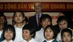 First Deputy Managing Director of the International Monetary Fund John Lipsky (C, rear) poses for a photo with blind children during his visit to the Nguyen Dinh Chieu charity school for the blind in Hanoi March 22, 2010.