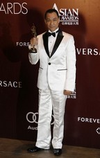 Chinese actor Wang Xueqi poses poses with his trophy after winning the Best Actor award at the Asian Film Awards in Hong Kong March 22, 2010.