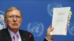 Michael Kirby, Chairperson of the Commission of Inquiry on Human Rights in North Korea, holds a copy of his report.