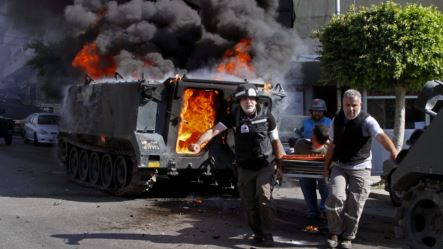 Medics transport an injured Lebanese soldier, after clashes between followers of a radical Sunni cleric Sheik Ahmad al-Assir and Shiite gunmen, in the southern port city of Sidon, Lebanon, June 23, 2013. 