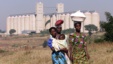 Malawian women walk past empty grain silos in the capital Lilongwe, (File photo).