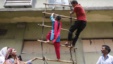 Garment workers from textile company Envoy Group demonstrate climbing a makeshift ladder, which serves as a fire exit to the building, during a protest in Dhaka, June 10, 2013. 