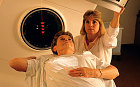 LINEAR ACCELERATOR USED TO DESTROY BREAST CANCER CELLS PATIENT AIDED BY RADIATION TECHNOLOGIST
