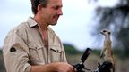 Cameraman Toby Strong with a meerkat (c) BBC