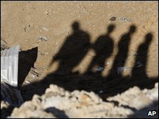 Shadows of Palestinians at the site of an Israeli strike in Gaza City, 8 January 2010