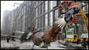 Workers move an installation art work entitled Phoenix by Chinese artist Xu Bin made of various waste metal materials in Beijing.