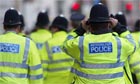  A police officer ensures his hat is in place as he rushes to join colleagues