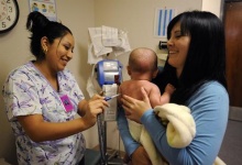 Certified nursing assistant Natalie Gutierrez (L) works with Ashley Ludwick and her baby Noah Gonzales at Sagebrush Clinic in Bakersfield, California October 20, 2009. REUTERS/Phil McCarten
