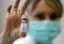  A medical assistant holds up a H1N1 flu vaccine, December 17, 2009. REUTERS/Djordje Kojadinovic 