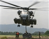 U.S. Marines attach a pallet of construction supplies to a CH-53E Super Stallion helicopter.