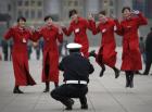Policjant robi zdjęcie grupie kobiet przed Wielką Halą Ludową w Pekinie, Chiny