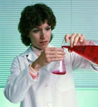 photo of scientist pouring contents of vial into beaker