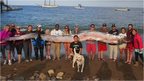 Beach goers posing with the 18ft oarfish