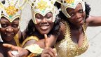 Women pose in their costumes in a procession during the yearly Lagos carnival on 9 April 2012