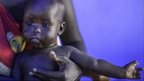 A displaced woman who fled Bor with one of her five children pictured in Mingkkaman, Lakes State, South Sudan