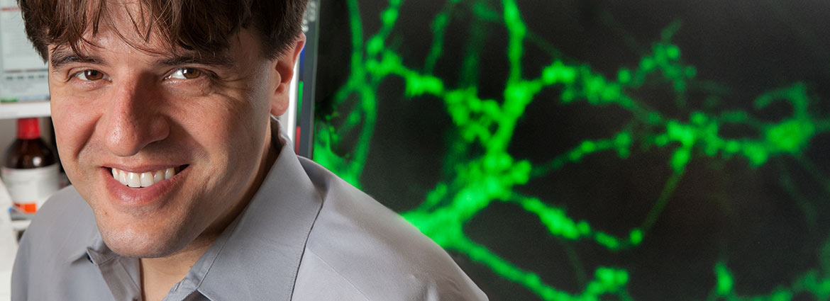 Karl Deisseroth in front of a sceen showing neurons 
