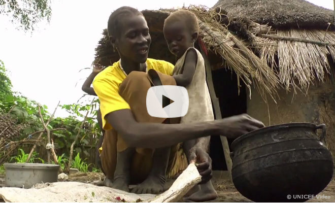 A woman in a village in South Sudan feeds her child from a pot