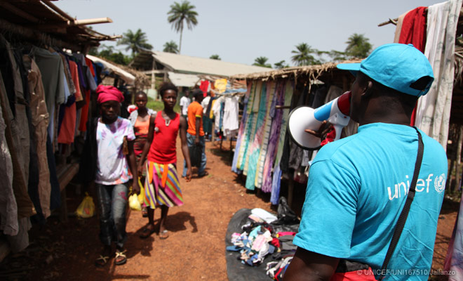 A UNICEF worker in Lofa County, Liberia, uses a megaphone to share information on the Ebola virus disease and how to prevent its spread 