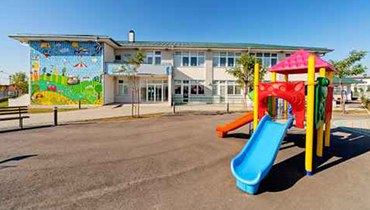 Preschool building with mural and playground