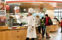 Arillaga Family Dining Commons cafeteria: chef, students and staff near the grill section.