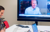 Staff (two female, one male) videoconferencing with a colleague working remotely.