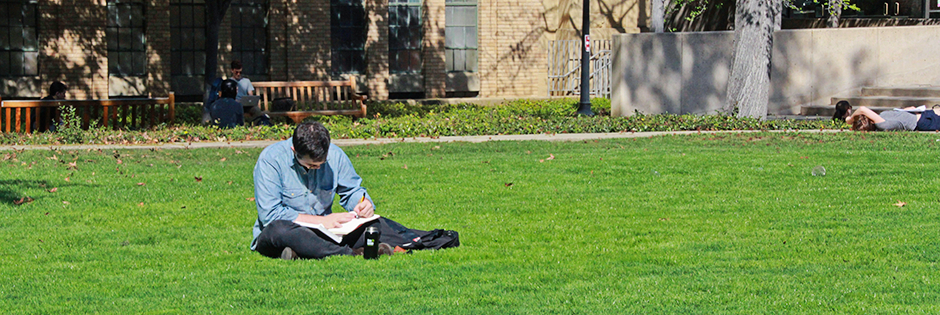 Stanford student writes on the lawn.