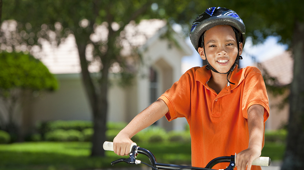 Boy on his bicycle, wearing his bicycle helmet