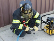 Photo of a firefighter testing the improved structure firefighting glove during an operational field assessment