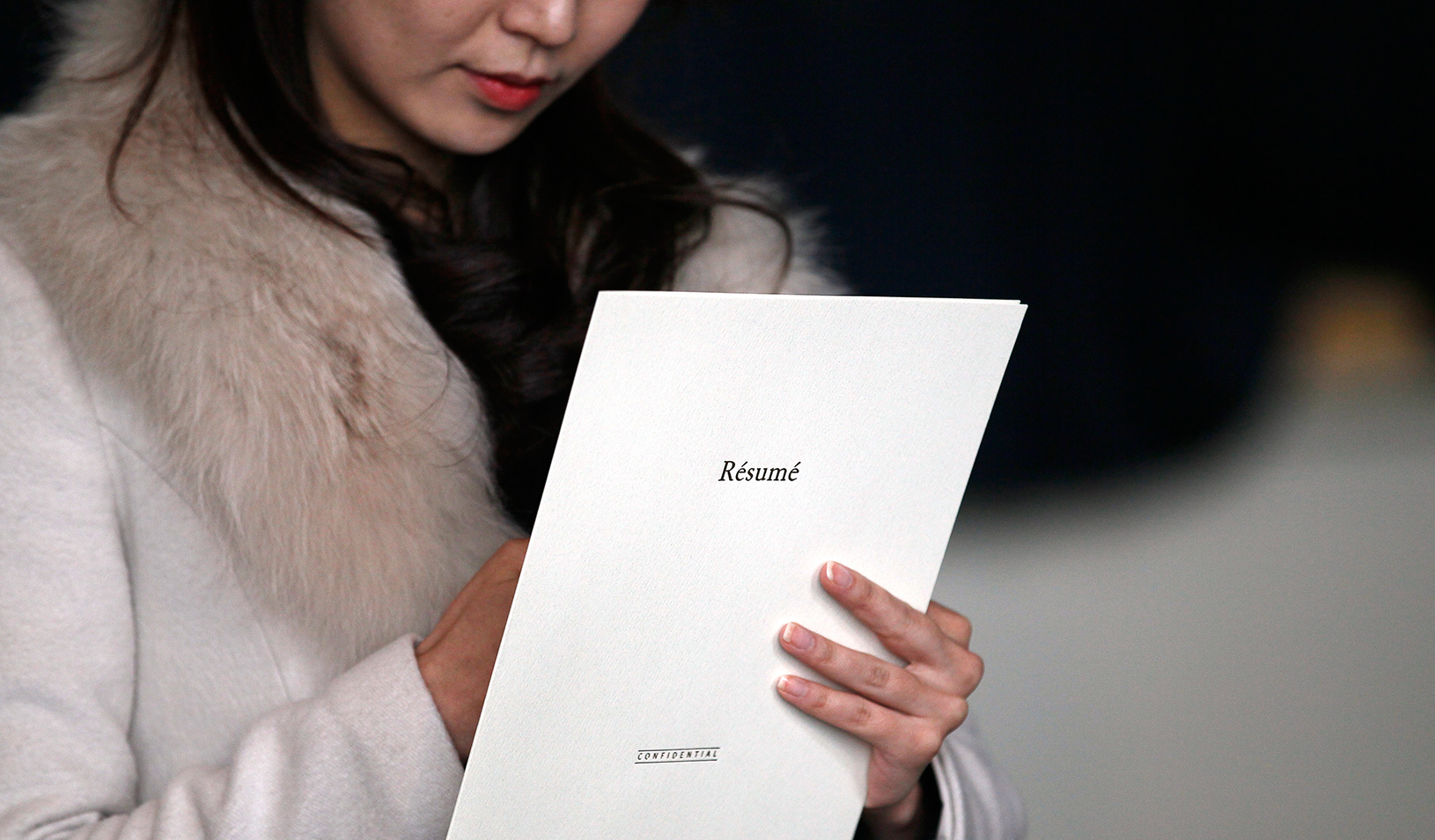 Woman holding resume folder while taking notes | Reuters/Rick Wilking
