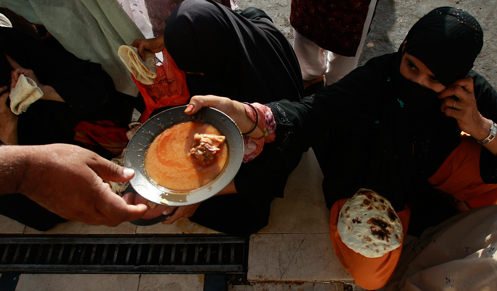 A woman handing a dish of food to someone else