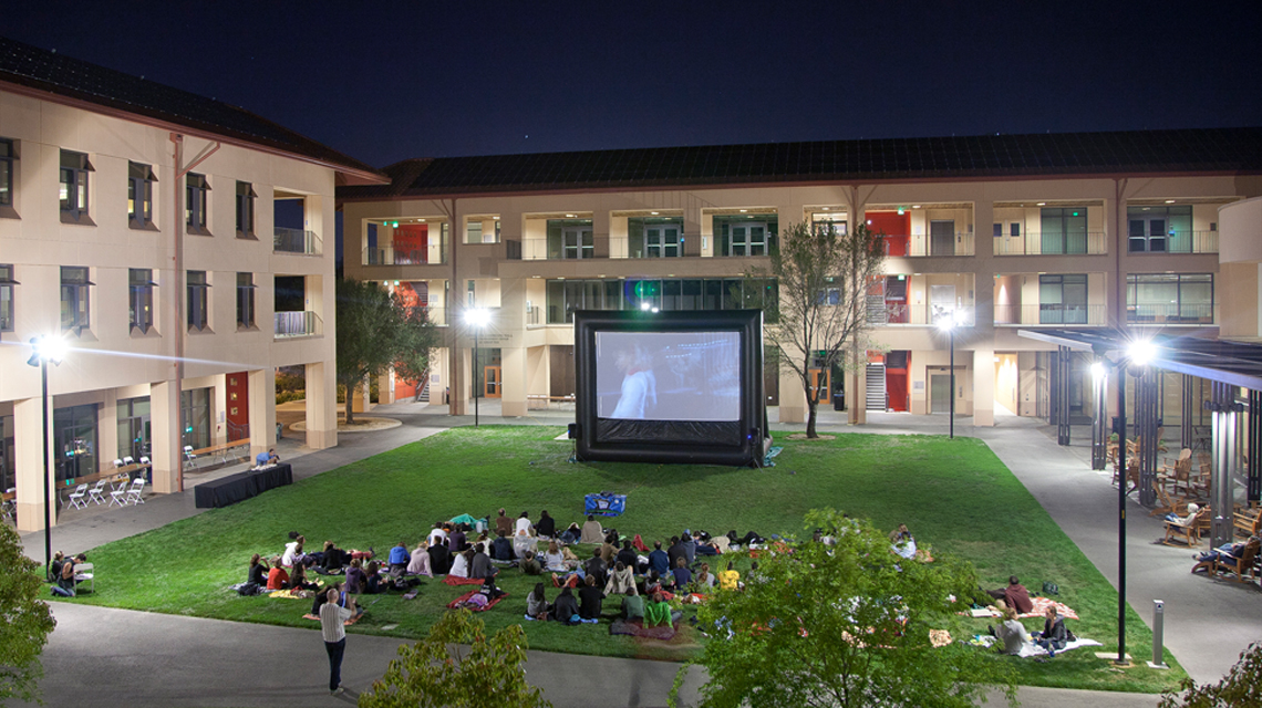 Students watching a movie in the Community Court at night