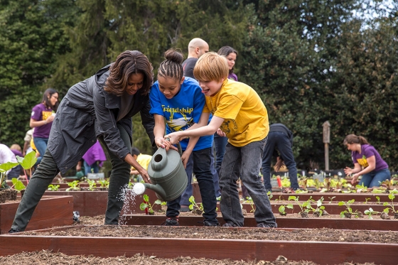 First Lady Michelle Obama helps students water newly planted vegetables as she joins FoodCorps leaders and local students for the spring garden planting in the White House Kitchen Garden, April 2, 2014.