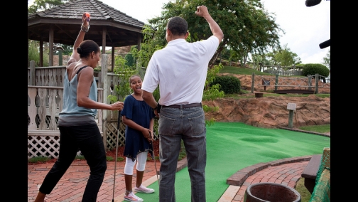 President Barack Obama and First Lady Michelle Obama play mini golf with daughter Sasha in Panama City Beach, Fla