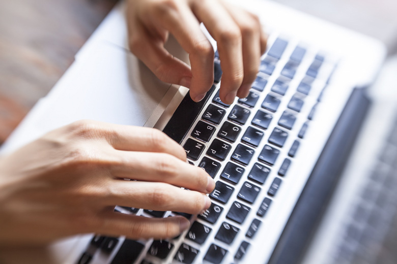hands typing on computer keyboard / De Visu/Shutterstock