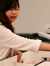 Michelle Kwon, class of '16, discusses an exhibition model during her summer 2014 internship at the de Young.