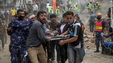 Emergency rescue workers carry a victim on a stretcher after Dharara tower collapses in the capital of Kathmandu.