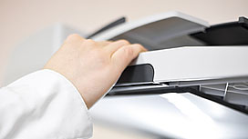 Photo of a hand opening a copy machine