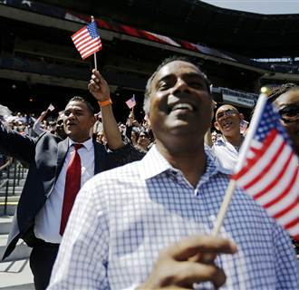 Image: Newly-sworn in U.S. citizens cheer during a naturalization ceremony for more than 1,000 citizenship candidates at Turner Field, home of the Atlanta Braves baseball team, on July 2, in Atlanta. 