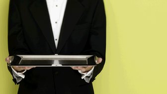 A waiter holds a silver tray