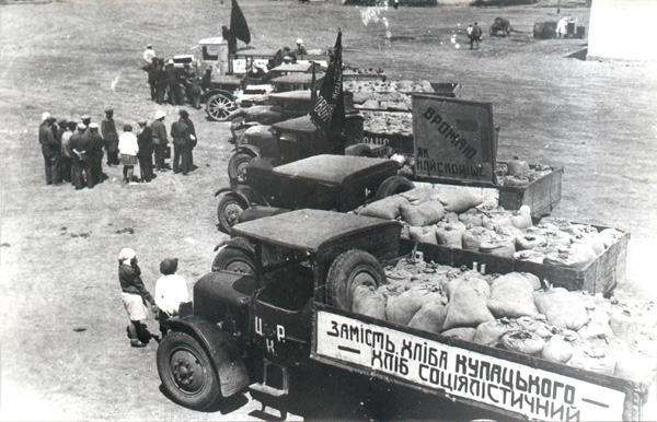 Shipment of grain from the Chervonyi Step collective farm to a procurement center, Kyivs'ka oblast', 1932. The sign reads 'Socialists' bread instead of kulak's bread.'