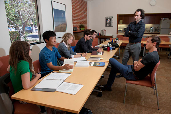 High school students at a table with with Stanford Professor Dan Edelstein (standing) and resident counselor Nathan Lindborg at the Summer Humanities Institute.