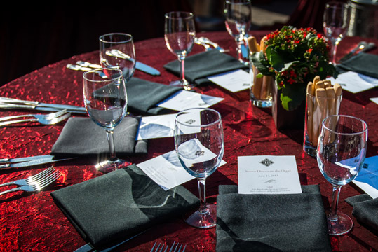 Stanford Catering table setup with red linen, black napkins and silverware. 