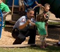 photo of public safety officer playing with his son on the playground