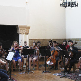 The ensemble acclimates to the acoustics of Toyon Hall in preparation for their upcoming concert. (CATALINA RAMIREZ-SAENZ/The Stanford Daily)