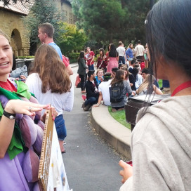 A staff member from the Office of Sustainability talks with students after they disposed of their lunch waste in the compost bins. Staffers dressed up in costumes and held signs to raise awareness about composting. (EMMA JOHANNINGSMEIER/The Stanford Daily)